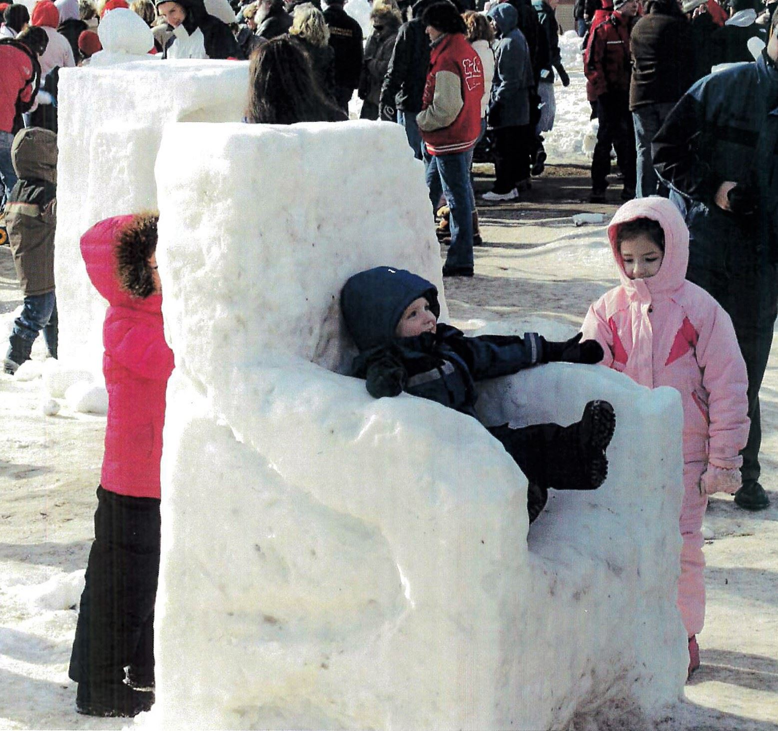 Kids sitting in snow sculpture