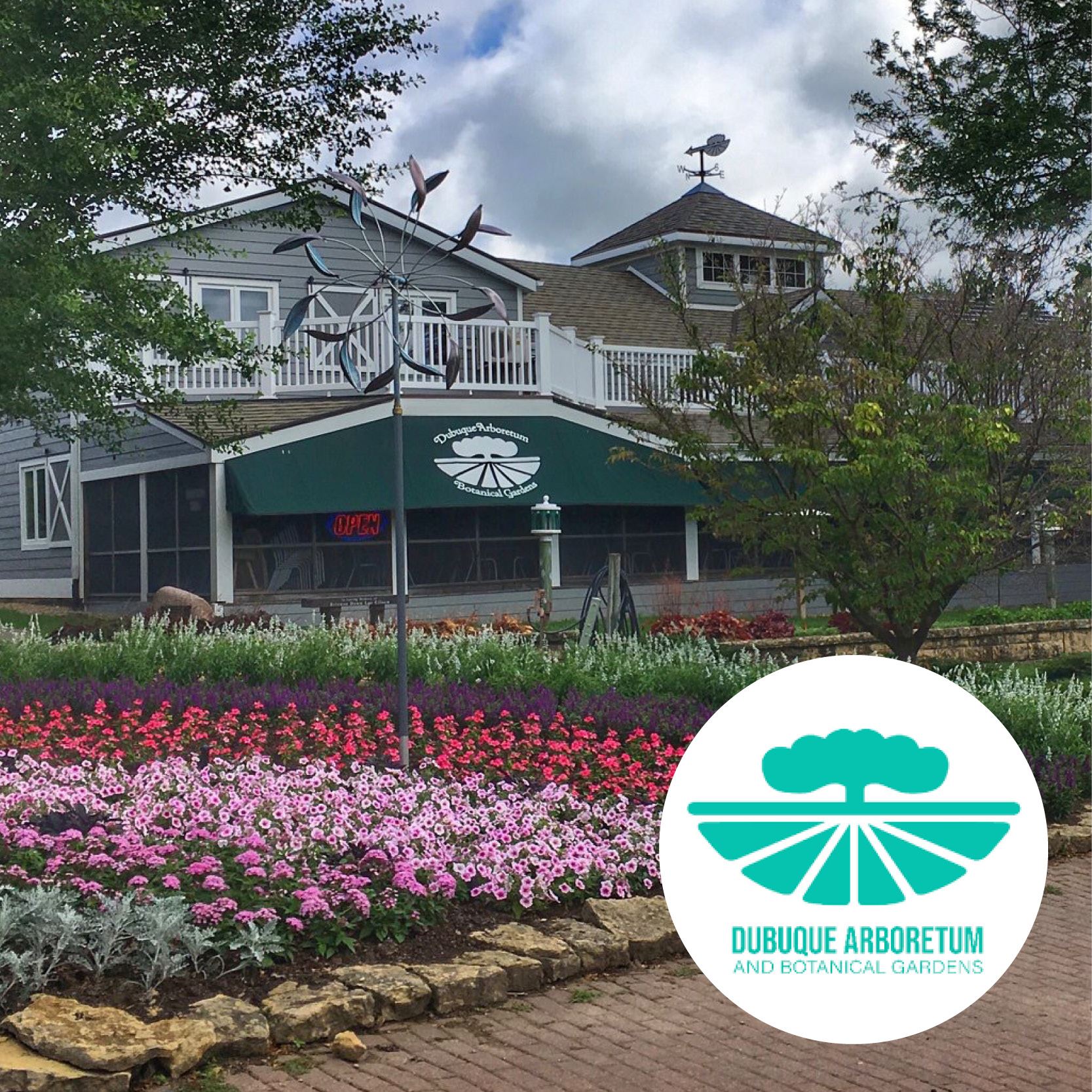 rows of colorful flowers in front of the arboretum building