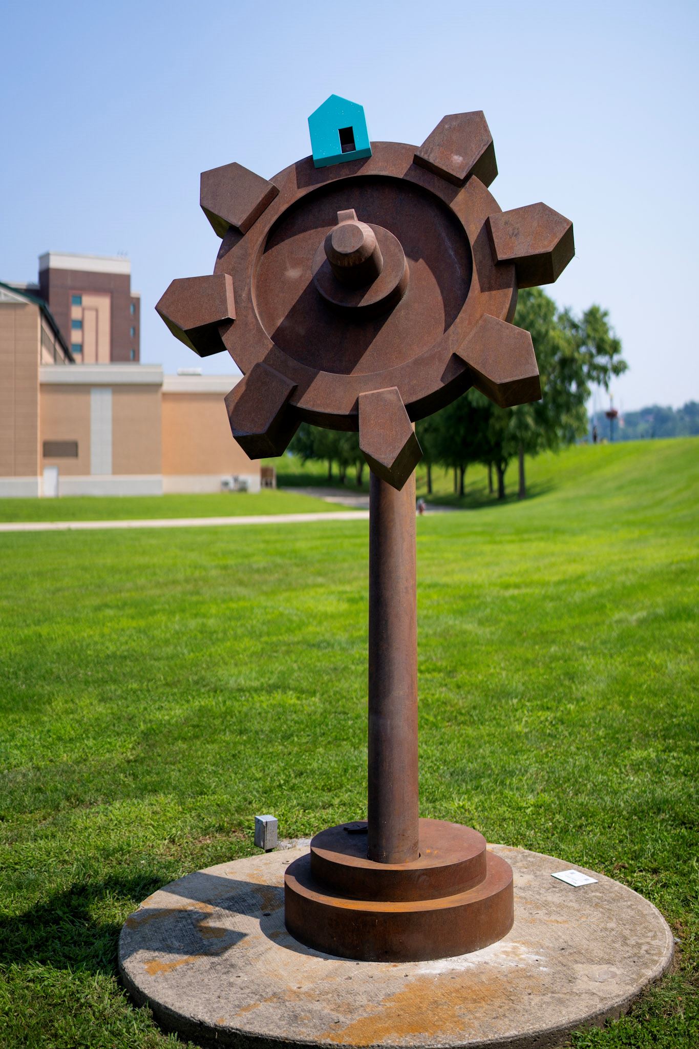 tall steel sculpture with a large circular gear at the top