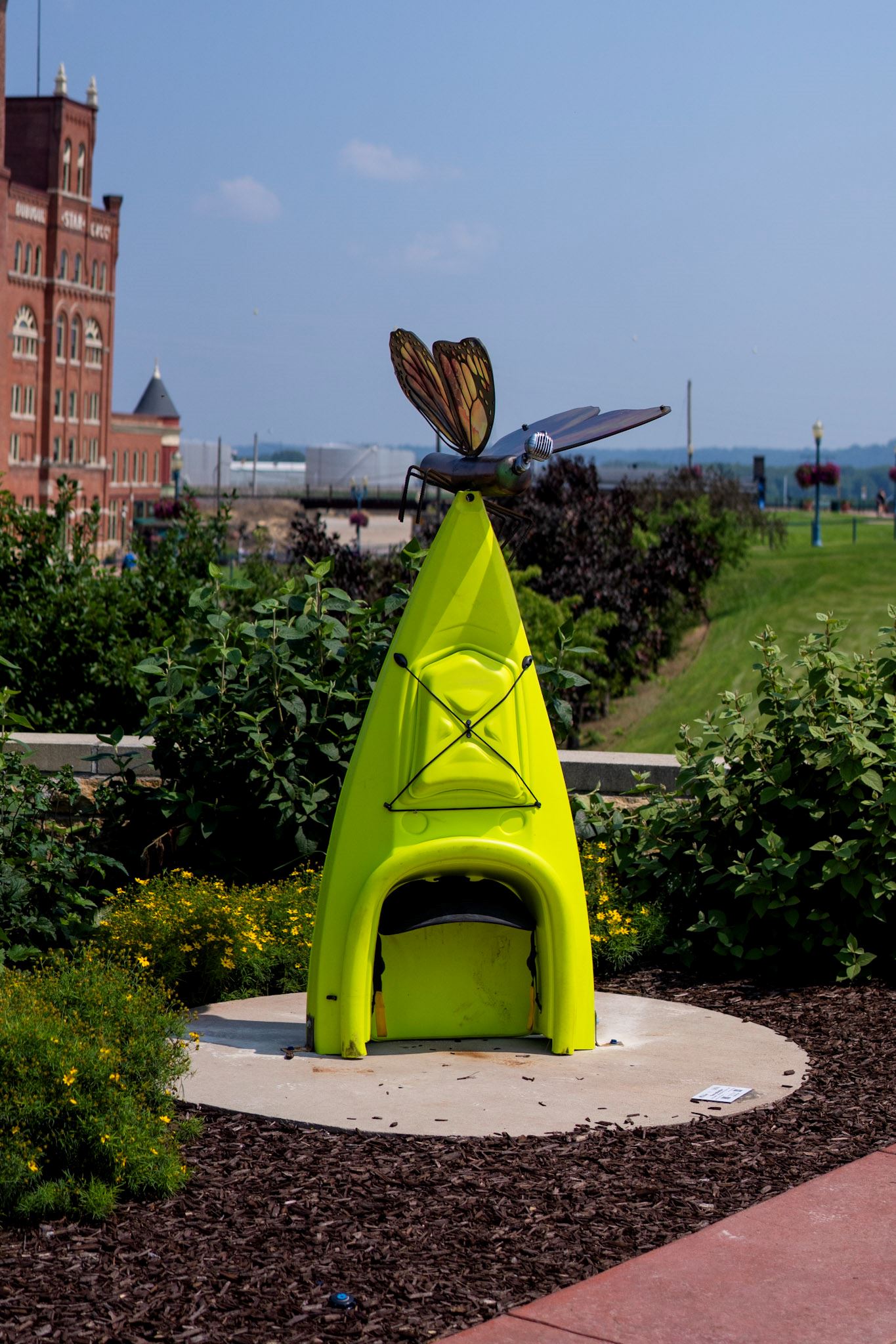 half of a bright green kayak with a butterfly sculpture sitting on top